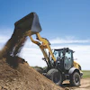 Yellow wheel loader dumping soil at a construction site under clear blue sky