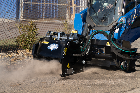 Blue industrial truck with black attachment equipment creating dust clouds at a construction site