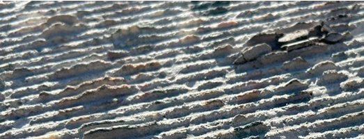 Aerial view of ridged terrain with shadow patterns creating natural linear formations across the landscape