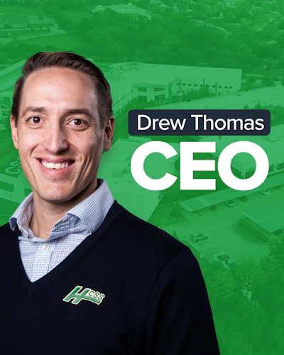 Drew Thomas, CEO, professional headshot with green background and industrial facility