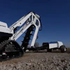 White Vermeer Interlune tracked skid steer loader on gravel ground under clear blue sky