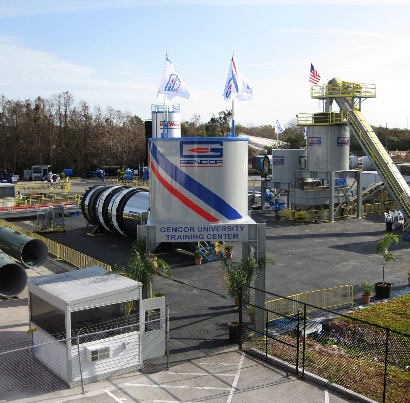 Gencor University Training Center industrial facility with blue and red striped branding, equipment towers, and flags