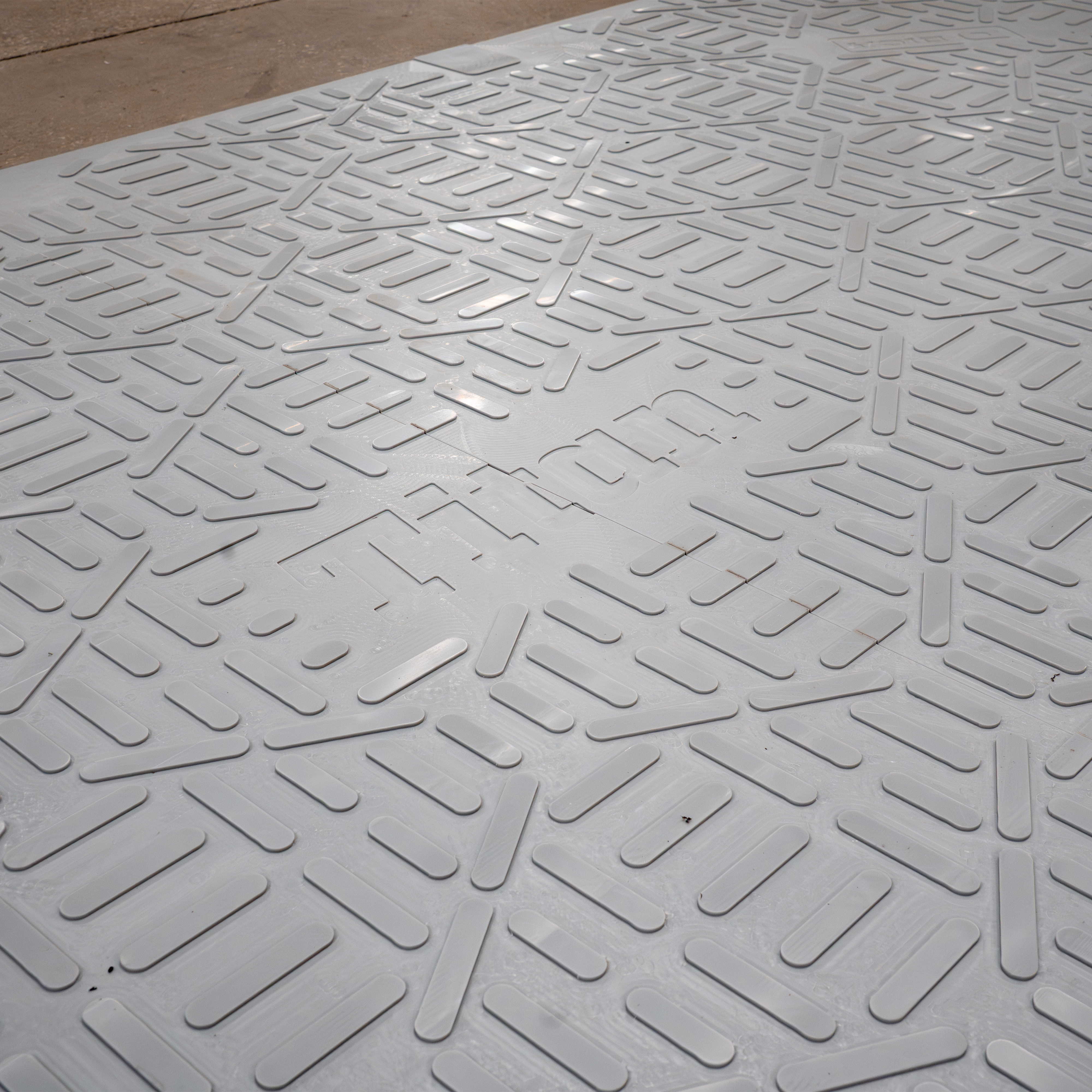 White embossed rubber mat with repeating geometric rectangular pattern for slip resistance and durability