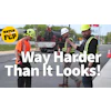 Construction workers in safety gear discussing road work project with equipment truck in background