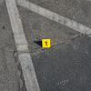 Yellow evidence marker numbered 1 on asphalt with white painted lines