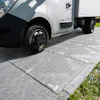 White commercial delivery van parked on textured paving with grass border