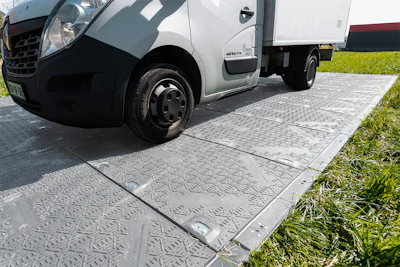White commercial delivery van parked on textured paving with grass border