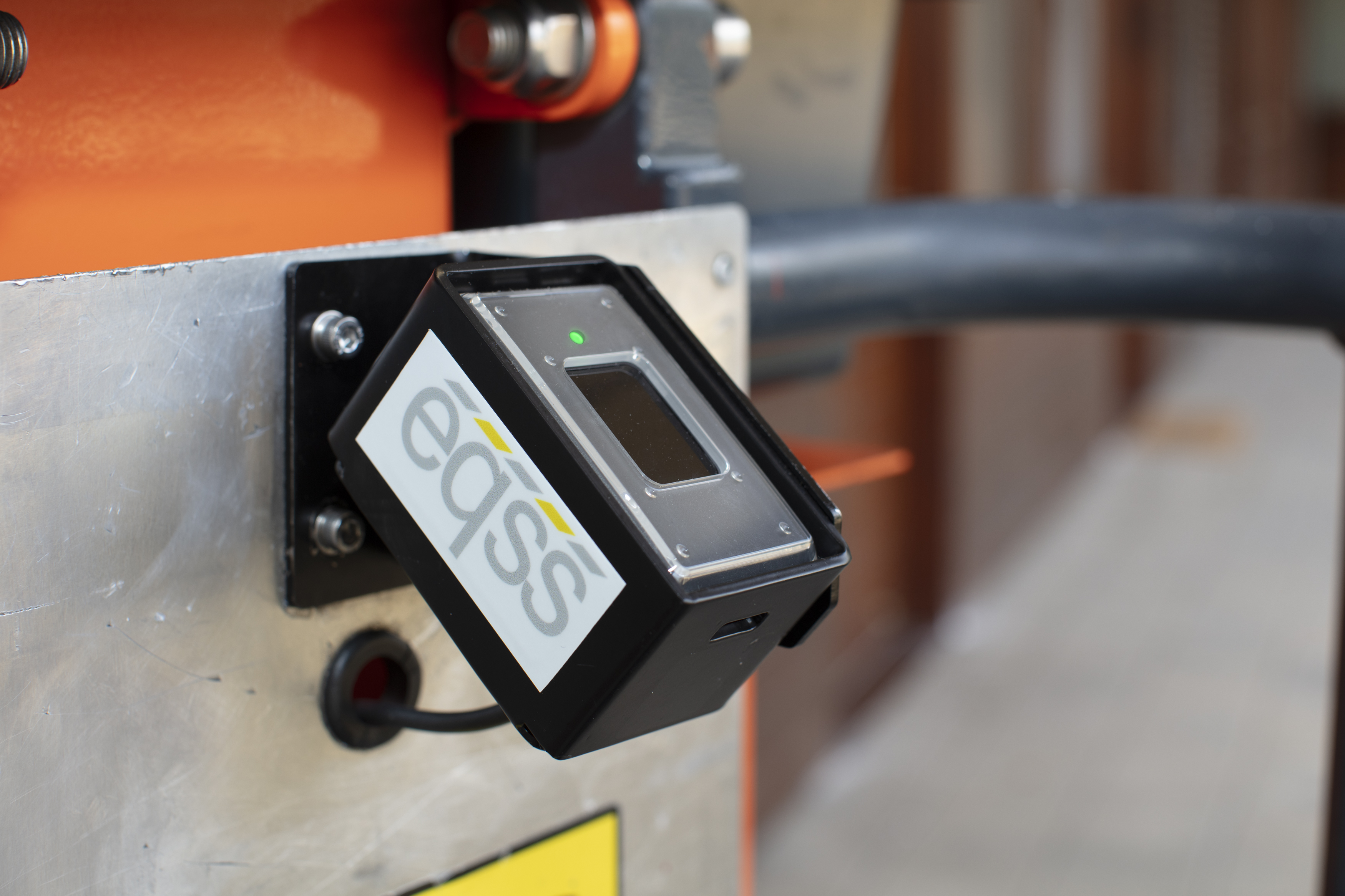 EOS sensor device mounted on industrial equipment with orange machinery visible in background
