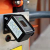 EOS sensor device mounted on industrial equipment with orange machinery visible in background