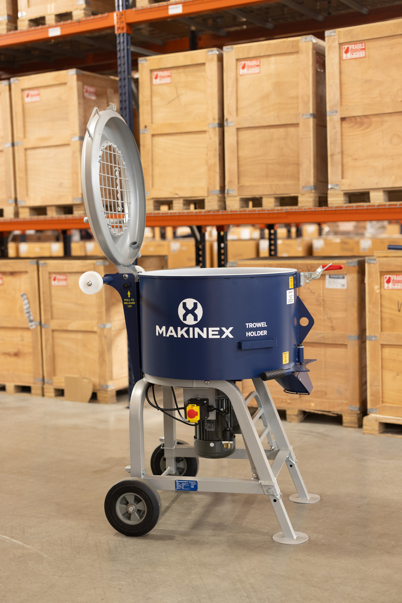 Makinex trowel holder mixer displayed in warehouse with wooden shipping crates