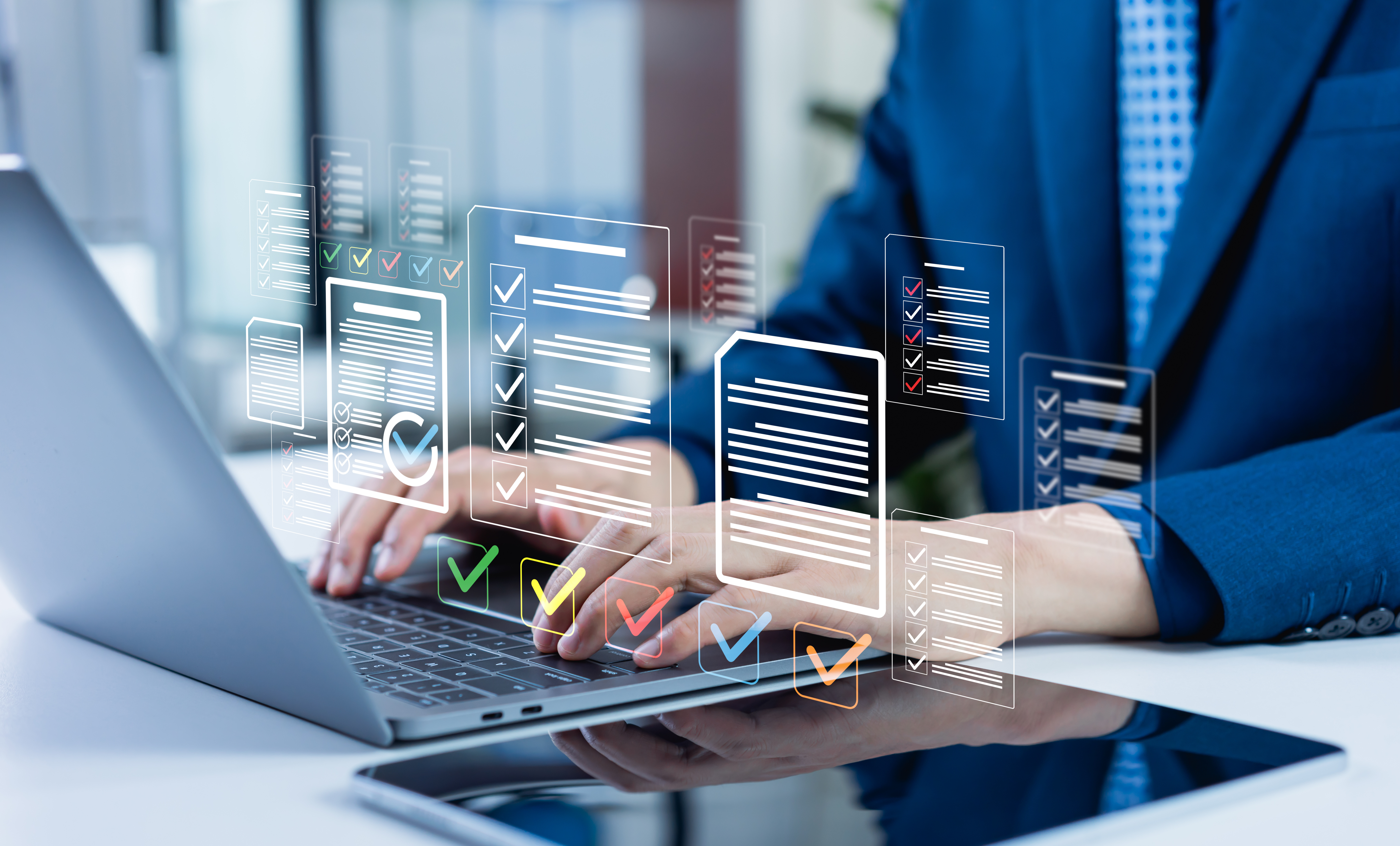 Professional in blue suit using laptop with holographic checklist and task management interfaces floating above keyboard