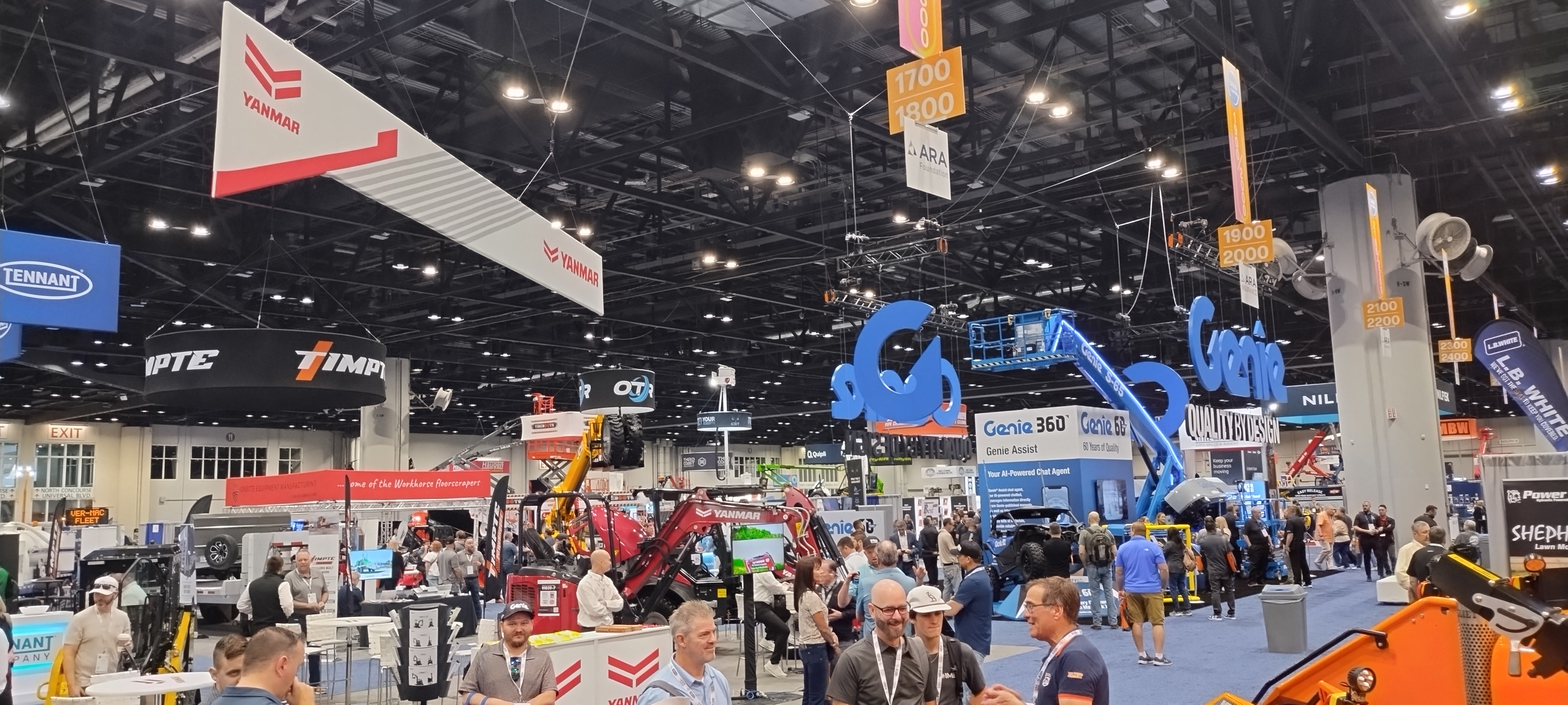 Industrial trade show exhibition floor with heavy equipment, vendor booths, and construction machinery displays