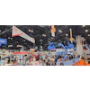 Industrial trade show exhibition floor with heavy equipment, vendor booths, and construction machinery displays