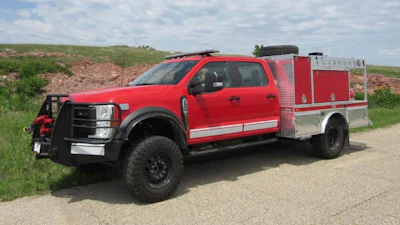 Red and silver fire truck with emergency equipment parked on rural road